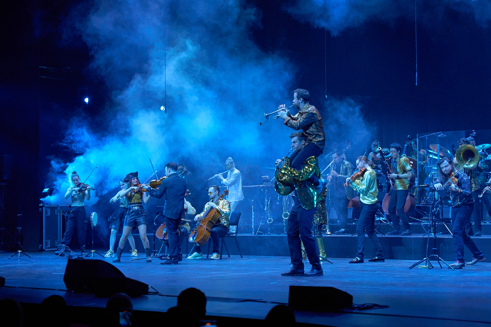The Limitless Orchestra performing under blue stage light